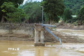Chân cầu treo Đền Vạn và hệ thống trụ cáp còn sót lại sau trận lũ lịch sử xảy ra vào tối 22 và rạng sáng ngày 23/7/2025. (Ảnh: Xuân Tiến/TTXVN)
