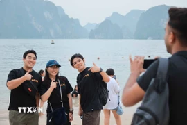 Du khách thích thú chụp ảnh “check in” khi đến với Hạ Long. (Ảnh: Hoàng Hiếu/TTXVN)