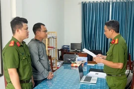 Cơ quan Công an thi hành Lệnh bắt tạm giam đối với Bùi Quang Huy. (Ảnh: TTXVN)