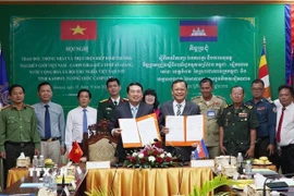 Phó Chủ tịch UBND tỉnh An Giang Lê Trung Hồ (trái) và ngài Khiev Rithiphorn, Phó Tỉnh trưởng tỉnh Kampot ký kết về trao đổi, thống nhất và triển khai Hiệp định Thương mại Biên giới Việt Nam - Campuchia. (Ảnh: TTXVN phát)