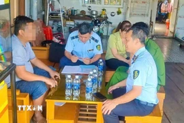 Lực lượng Quản lý thị trường thành phố Cần Thơ làm việc với một cửa hàng xăng dầu sau khi người dân phản ánh. (Ảnh: TTXVN phát)