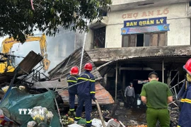 Lực lượng chức năng có mặt kịp thời khống chế ngọn lửa. (Ảnh: Đỗ Trưởng/TTXVN)