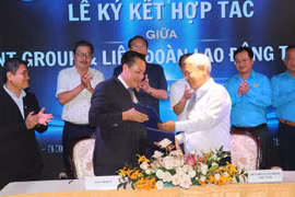 Ông Võ Khắc Thái, Phó Chủ tịch Liên đoàn Lao động TP. Hồ Chí Minh và ông Lê Xuân Lành, Chủ tịch Hội đồng Quản trị Công ty Cổ phần Phát triển Dịch vụ LNT 7979 thực hiện nghi thức ký kết bản ghi nhớ hợp tác xây dựng 30.000 nhà ở xã hội cho công nhân. (Ảnh: Thanh Vũ/TTXVN)