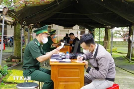 Lực lượng chức năng tỉnh Đồng Tháp tiếp nhận công dân Việt Nam do phía Campuchia trao trả. (Ảnh: TTXVN phát)