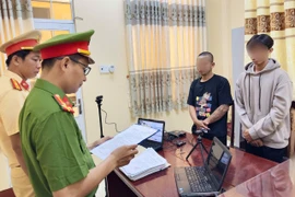 Cơ quan Cảnh sát điều tra tống đạt quyết định khởi tố bị can, lệnh cấm đi khỏi nơi cư trú đối với Võ Duy Khang (áo đen) và Phạm Văn Ý (áo xám)