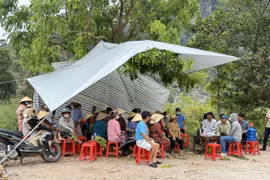 Sáng 12/5/2025, hàng trăm người dân căng bạt, dựng lều…tập trung tại cổng khu vực bãi rác Đông Nam để ngăn các xe chở rác vào tập kết tại bãi. (Ảnh: Khiếu Tư/TTXVN)