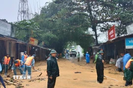 Hàng chục bộ đội, dân quân, công an, đoàn thanh niên xã cùng người dân tham gia khắc phục bùn đất tại Trà Tân, thành phố Đà Nẵng. (Ảnh: TTXVN phát)