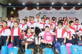 Lãnh đạo Thành ủy Thành phố Hồ Chí Minh chụp ảnh kỷ niệm với các bệnh nhi tham gia Lớp học Hoa hướng dương. (Ảnh: Đinh Hằng/TTXVN)