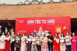 Đại diện Ban tổ chức trao chứng nhận tham gia trưng bày tranh “Dân tộc tự hào” cho các họa sỹ. (Ảnh: Tuyết Mai/TTXVN)