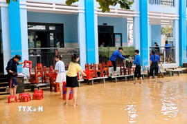 Mặc dù nước chưa rút hết khỏi sân trường nhưng các cô giáo trường Tiểu học Kim Đồng, phường Điện Bàn đã đến trường để dọn dẹp vệ sinh. (Ảnh: Anh Dũng/TXVVN)
