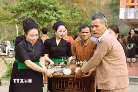 Người dân Ơ Đu di chuyển mâm cúng thần Sấm ra địa điểm cúng được thực hiện ngoài trời. (Ảnh: Xuân Tiến/TTXVN)