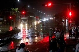 Quốc lộ 1A, đoạn qua phường Hàm Thắng (Lâm Đồng) bị ngập sâu, các phương tiện lưu thông khó khăn. (Ảnh: Nguyễn Thanh/TTXVN)