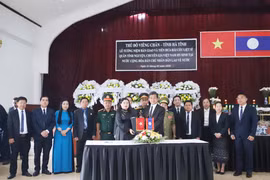 Ban Công tác đặc biệt thủ đô Viêng Chăn và Ban Công tác đặc biệt tỉnh Hà Tĩnh trao biên bản bàn giao hài cốt liệt sỹ. (Ảnh: Xuân Tú/TTXVN)