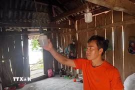 Gia đình anh Thảo A Phừ, bản Sa Lung, xã miền núi Mường Lý chưa được sử dụng điện lưới, phải nấu cơm bằng bếp củi, thắp đèn pin. (Ảnh: Nguyễn Nam/TTXVN)