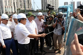 Chủ tịch Ủy ban Nhân dân Thành phố Hồ Chí Minh Nguyễn Văn Được trao đổi tại công trường. (Ảnh: Tiến Lực/TTXVN)