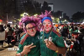 Các cổ động viên hóa trang rực rỡ ăn mừng chiến thắng của đội tuyển Mexico trước Ecuador. (Ảnh: Phương Lan/TTXVN)