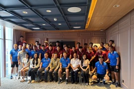 Đại sứ Tạ Văn Thông cùng cán bộ Đại sứ quán Việt Nam, cộng đồng người Việt tại Indonesia chụp ảnh lưu niệm cùng đội tuyển U23 Việt Nam. (Ảnh: Minh Thái/TTXVN)