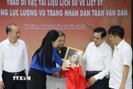 Lãnh đạo tỉnh Hà Tĩnh cùng trao tặng các kỷ vật, tài liệu lịch sử và di ảnh phục dựng của liệt sỹ cho thân nhân gia đình. (Ảnh: Hoàng Ngà/TTXVN)