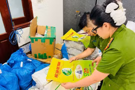 Lực lượng chức năng kiểm tra bao bì giả thương hiệu gạo ST25. (Ảnh: TTXVN)