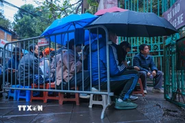 Nhiều người dân đã đến từ 6h xếp hàng chờ đợi làm thủ tục cấp, đổi giấy phép lái xe tại Bộ phận tiếp nhận và trả kết quả giải quyết thủ tục hành chính (16 Cao Bá Quát, Ba Đình, Hà Nội). (Ảnh: Hoàng Hiếu/TTXVN)