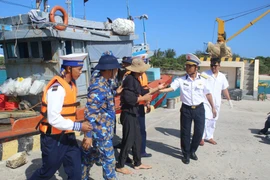 Đưa ngư dân gặp nạn vào đảo Song Tử Tây để điều trị gãy ngón tay do tai nạn lao động. (Ảnh: TTXVN phát)