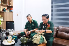 Cựu chiến binh Đoàn Xuân Luyến (phải) trân quý những kỷ vật của một thời chiến đấu oanh liệt tại chiến trường Quảng Trị. (Ảnh: Tường Vi/TTXVN)
