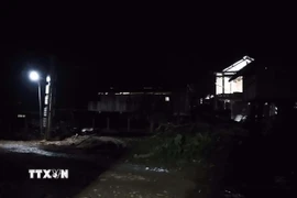 Lần đầu tiên ánh sáng điện lưới quốc gia thắp sáng thôn Tu Thôn. (Ảnh: TTXVN phát)