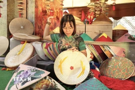 Nghệ nhân Phạm Thị Vấn làng Chuông, Hà Nội biểu diễn làm nón tại hội chợ. (Ảnh: Trần Việt/TTXVN)
