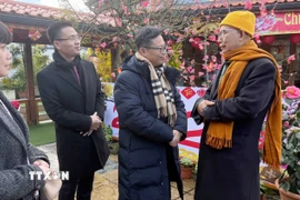 Đại sứ Việt Nam tại Pháp Trịnh Đức Hải (ngoài cùng bên phải) gửi lời chúc mừng năm mới tới Hòa thượng Thích Thịnh Quang, Trụ trì chùa Khuông Việt. (Ảnh: Hữu Chiến/TTXVN)