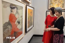 Các nữ họa sỹ tham gia triển lãm tranh. (Ảnh: Phương Thanh/TTXVN)