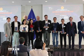 Các diễn giả tại hội thảo nhận quà lưu niệm từ Ban Tổ chức. (Ảnh: Hương Giang/TTXVN)