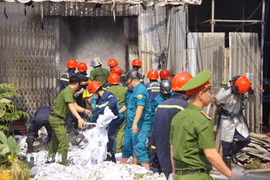 Lực lượng chức năng khống chế đám cháy tại nhà kho chứa vải ở phường An Khê, thành phố Đà Nẵng. (Ảnh: TTXVN phát)