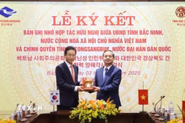 Chủ tịch Ủy ban Nhân dân tỉnh Bắc Ninh Phạm Hoàng Sơn (bên phải) tặng biểu tượng trống Đồng cho ngài Lee Cheol Woo, Tỉnh trưởng tỉnh Gyeongsangbuk (Hàn Quốc). (Ảnh: Thanh Thương/TTXVN)