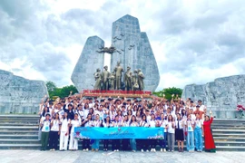 110 thanh niên, sinh viên kiều bào tiêu biểu và các đại biểu chụp ảnh lưu niệm bên Tượng đài Chủ tịch Hồ Chí Minh và nhân dân Quảng Bình (phường Đồng Hới, tỉnh Quảng Trị). (Ảnh: Võ Dung/TTXVN)