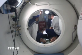 Các bác sỹ tiến hành cấp cứu cho ngư dân bị giảm áp. (Ảnh: TTXVN phát)