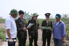 Cán bộ kiểm lâm Nam Định tuyên truyền cho người dân vùng ven biển về các quy định bảo vệ rừng ngập mặn. (Ảnh: Công Luật/TTXVN)