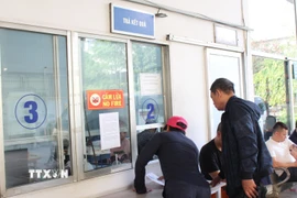 Các chủ xe bày tỏ hài lòng khi nhận kết quả đăng kiểm. (Ảnh: Nguyễn Thắng/TTXVN)