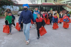 Các học sinh nghèo vùng cao Tuyên Quang vui mừng khi được nhận những phần quà Tết sớm. (Ảnh: Phan Phương/TTXVN)