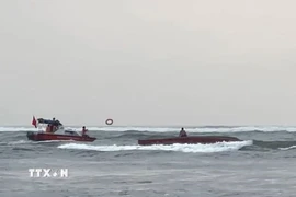 Đồn Biên phòng Nhật Lệ khẩn trương triển khai lực lượng, phương tiện tiếp cận tàu cá và cứu, đưa ngư dân Nguyễn Tiến Hoàng vào bờ. (Ảnh: TTXVN phát)