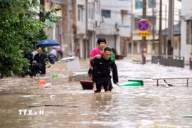 Lực lượng cứu hộ hỗ trợ người dân sơ tán khỏi khu vực ngập lụt tại huyện Tòng Giang, tỉnh Quý Châu, Trung Quốc ngày 24/6/2025. (Ảnh: THX/TTXVN)