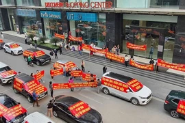 Cư dân Chung cư 302 đường Cầu Giấy (phường Dịch Vọng, quận Cầu Giấy, Hà Nội) tập trung trước sảnh tòa nhà, căng băng rôn đòi quyền lợi. (Ảnh: Thu Hằng/TTXVN)