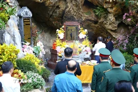 Các đại biểu dâng hương tại ngôi mộ chung các liệt sỹ tại Di tích quốc gia đặc biệt Hang Tám Cô. (Ảnh: Tá Chuyên/TTXVN)