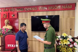 Cơ quan Cảnh sát điều tra, Công an tỉnh Quảng Ninh tống đạt Quyết định khởi tố bị can đối với Nguyễn Duy Hưng. (Ảnh: TTXVN phát)