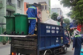 Công nhân ngành môi trường thu gom rác sinh hoạt tại phường Tân Bình, TPHCM. (Ảnh SGGP)