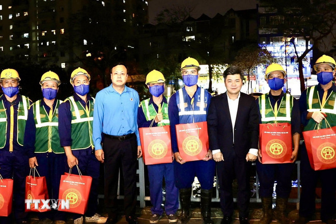 Lãnh đạo Công đoàn Thủ đô chia sẻ khó khăn, vất vả và tặng quà cho công nhân ngày đêm lao động để cải thiện môi trường. (Ảnh: TTXVN phát) ttxvn-cong-nhan-nao-vet-song-to-lich1.jpg