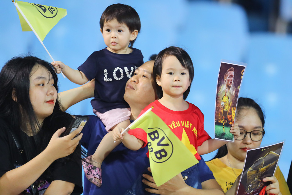 Một gia đình cổ động viên cổ vũ cho câu lạc bộ Borussia Dortmund có mặt trên sân Mỹ Đình trong buổi tập. (Ảnh: PV/Vietnam+)