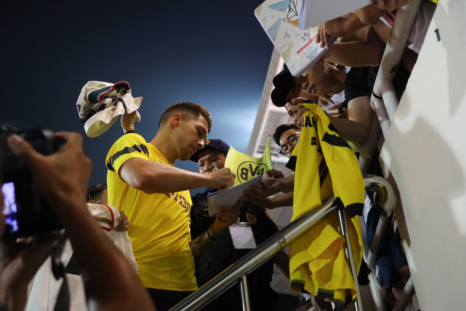 Kết thúc buổi tập, dàn cầu thủ nổi tiếng tiếp tục dành thời gian ký tặng cho nhiều người hâm mộ. (Ảnh: PV/Vietnam+)