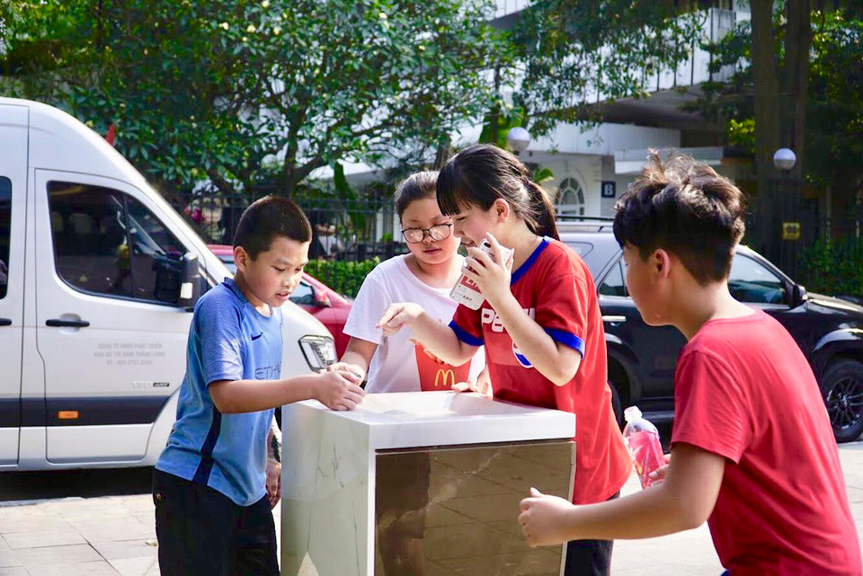 Nhóm bạn trẻ đang thích thú cùng nhau sử dụng vòi nước công cộng mới. (Ảnh: PV/Vietnam+)