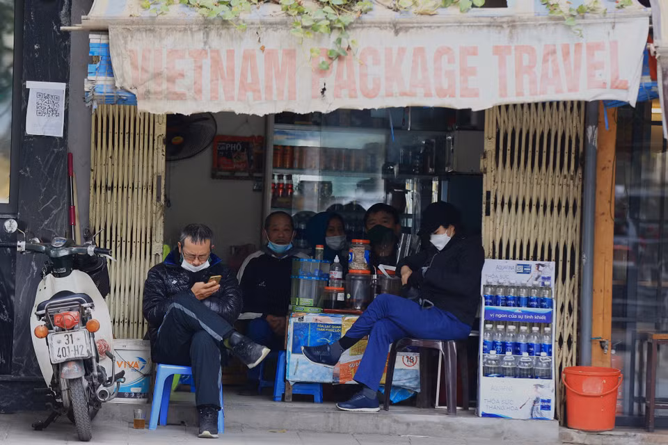 Không được ‘bày biện’ như trước, người dân sử dụng dịch vụ tại các quán nước vỉa hè này đành ngồi nép sát vào cửa và phía trong nhà. (Ảnh: Hoài Nam/Vietnam+)