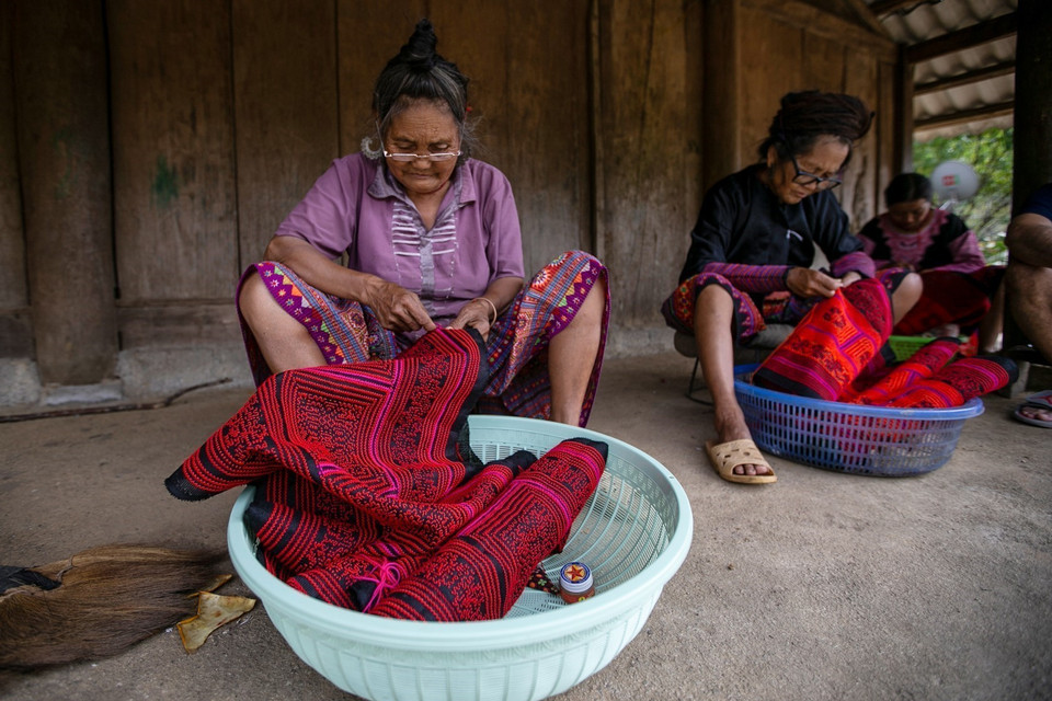 Những cụ già người Mông thêu thùa bên hiên nhà tại Hang Kia và Pà Cò. (Ảnh: Trọng Đạt/TTXVN)